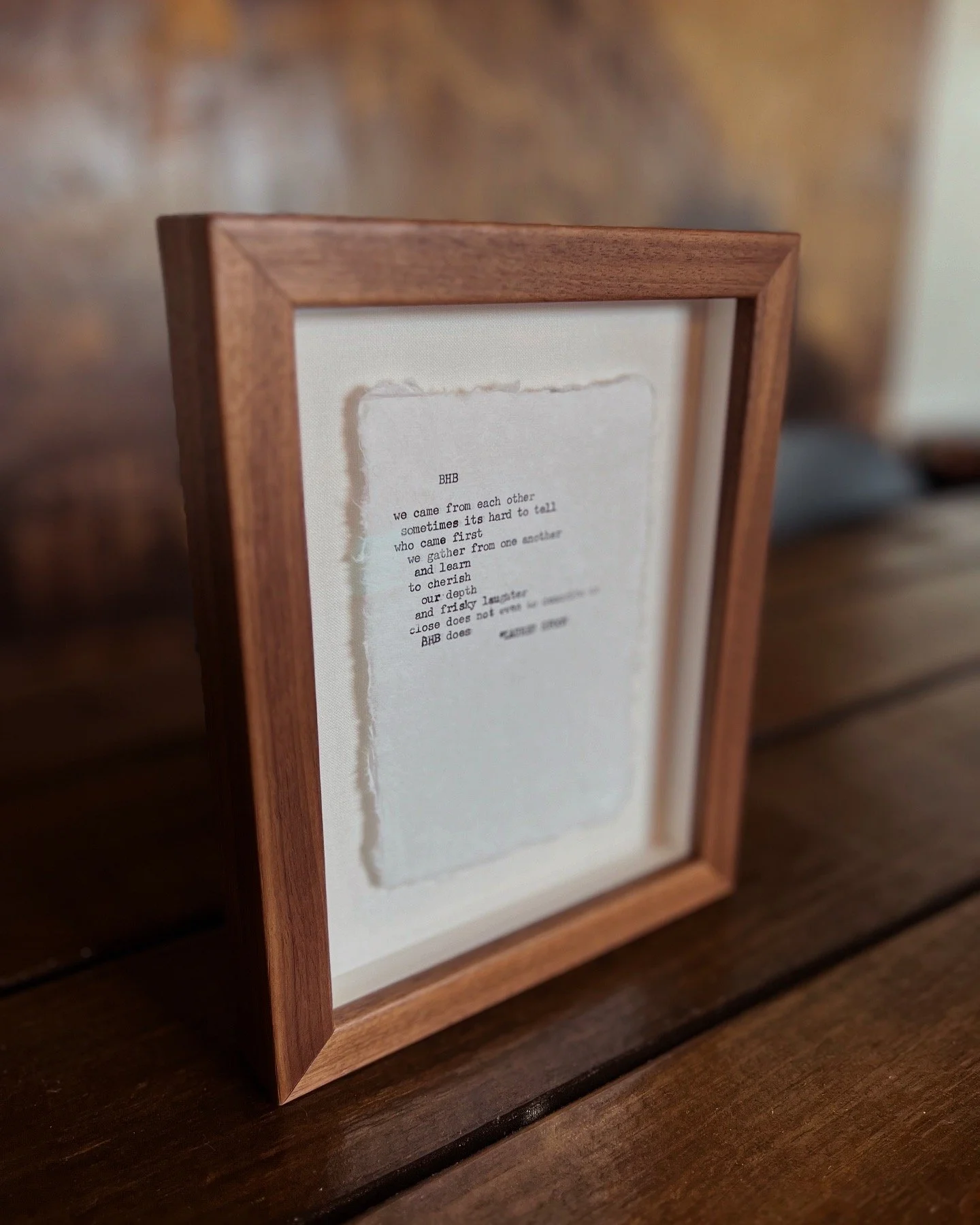 Typewritten poem on handmade paper floated in a walnut frame