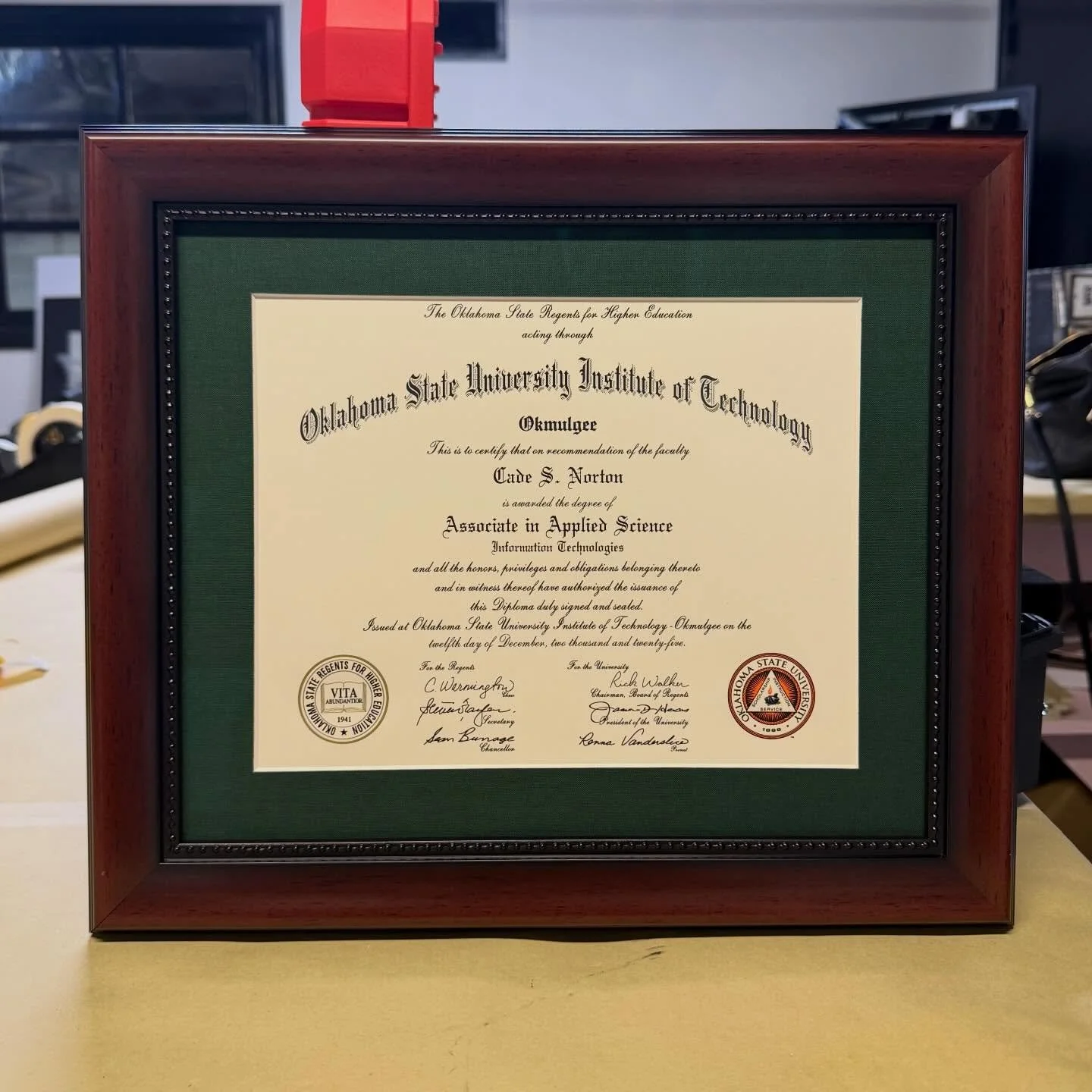 Diploma in a mahogany frame with a hunter green suede mat