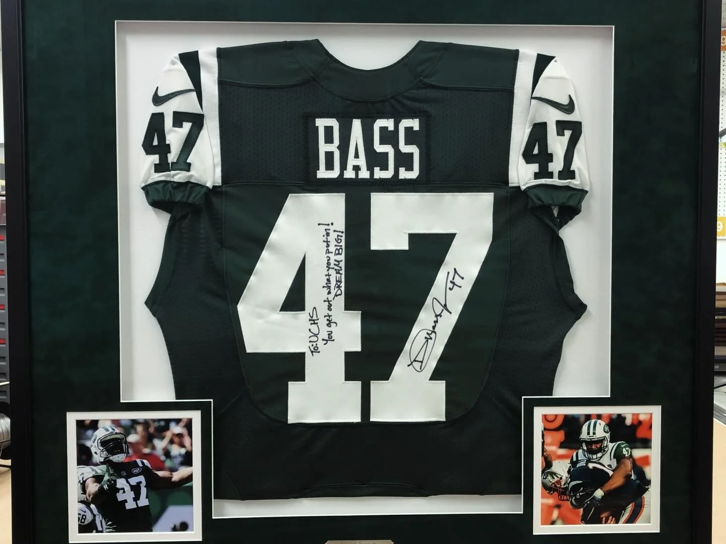 Autographed football jersey framed in a shadow box with a green suede mat